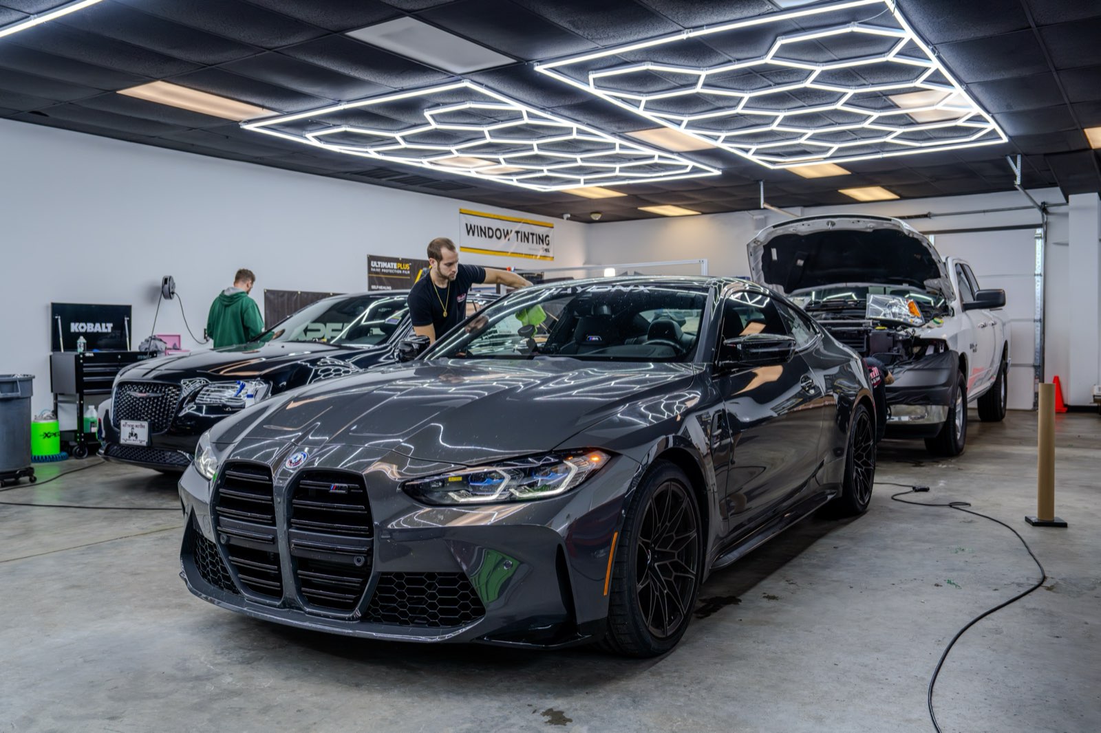 BMW M4 in professional detailing studio under hex lighting