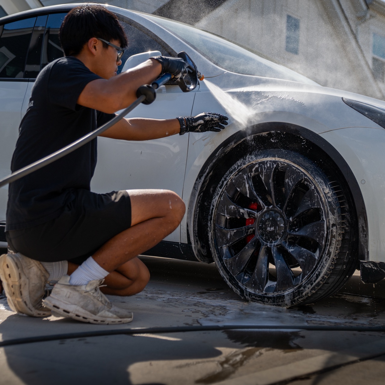 Detailer rinsing a vehicle during an exterior wash